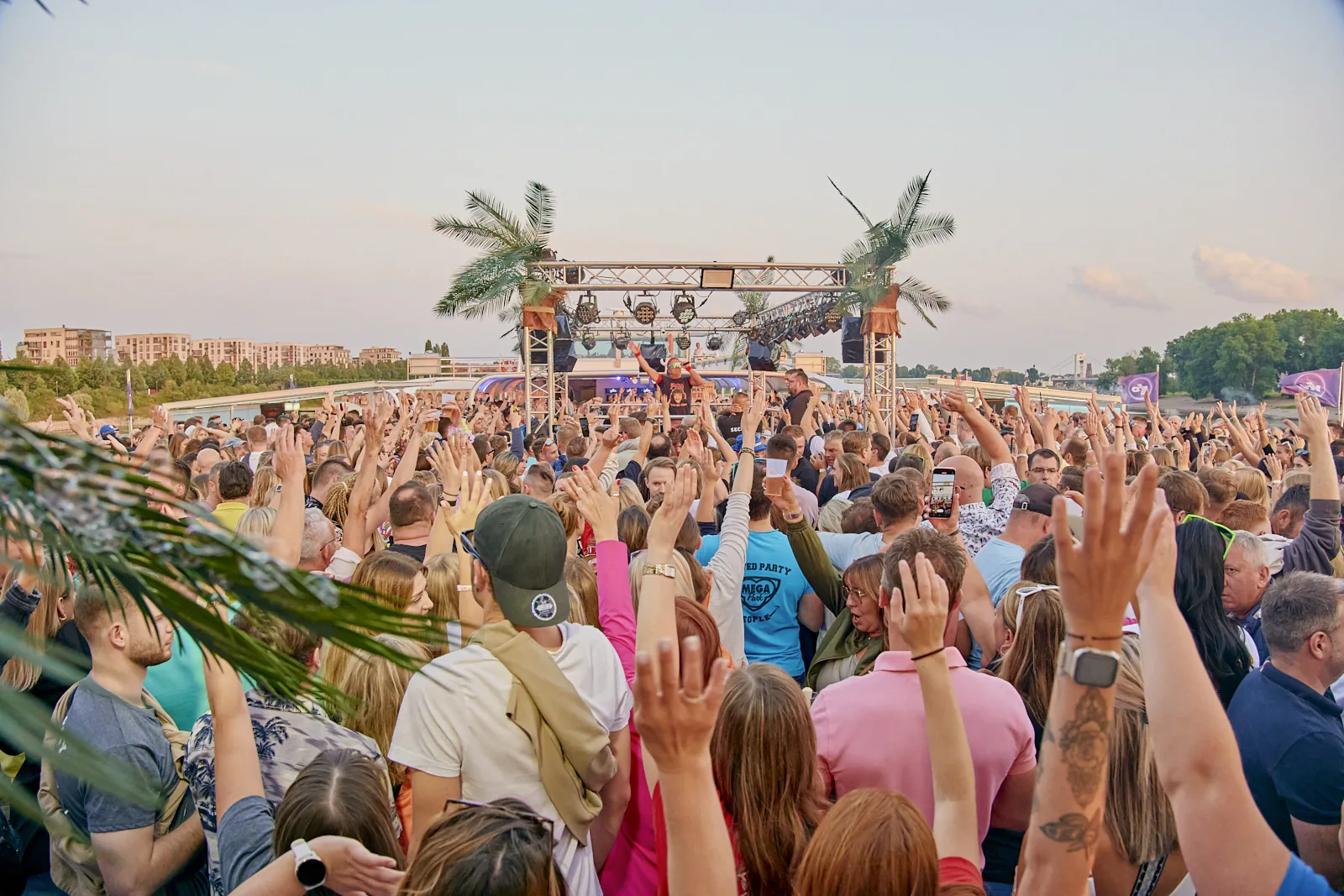 Feestende menigte onder palmen tijdens festival